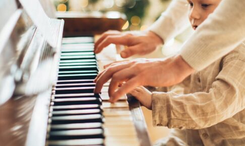 boy in white long sleeve shirt playing piano